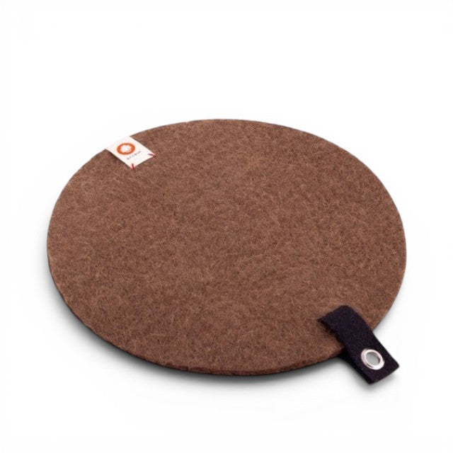 Baabuk round brown felted wool trivet hot plate with a small leather hanging strap on a white background.