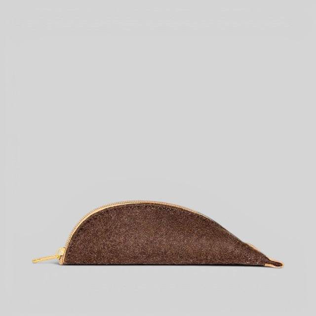 Baabuk brown wool pencil case with a gold zipper and leather accents, side view on a light grey background.