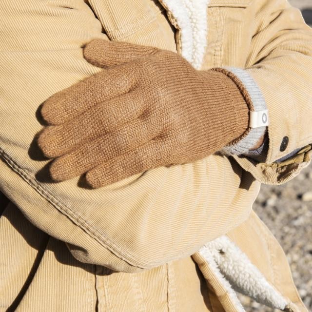 Baabuk camel-colored baby alpaca wool gloves worn by a person in a tan corduroy jacket for winter warmth.