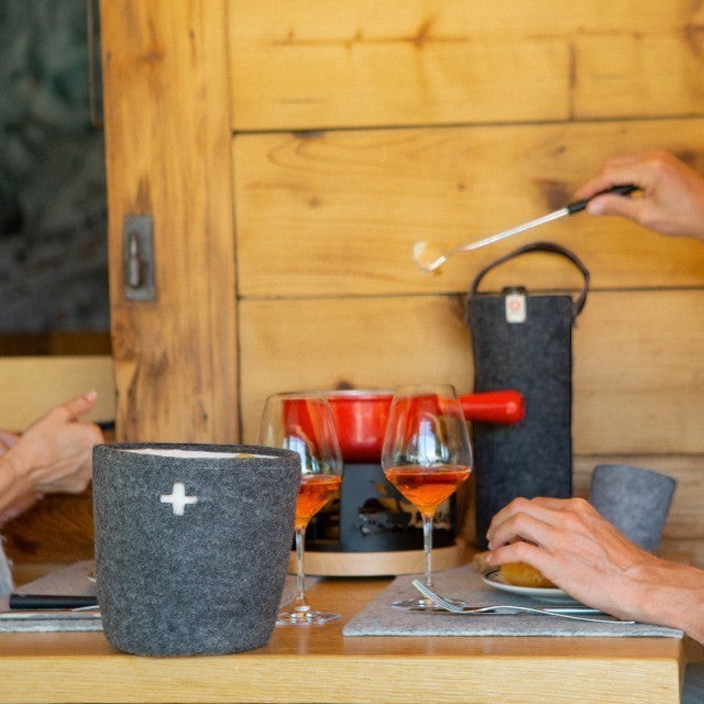 Baabuk dark grey felted wool table mat on a wooden dining table with fondue setting