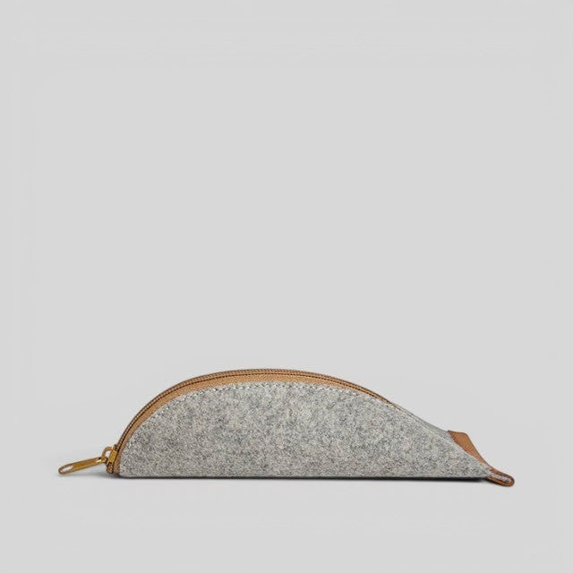 Baabuk grey wool pencil case with a brown leather zipper closure, side view on a neutral background.