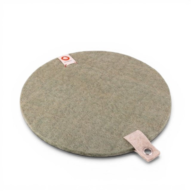 Baabuk round khaki felted wool trivet hot plate with a small leather hanging strap on a white background.
