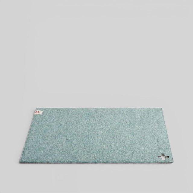 Baabuk light blue felted wool table mat with a small Swiss cross cutout detail on a plain background.