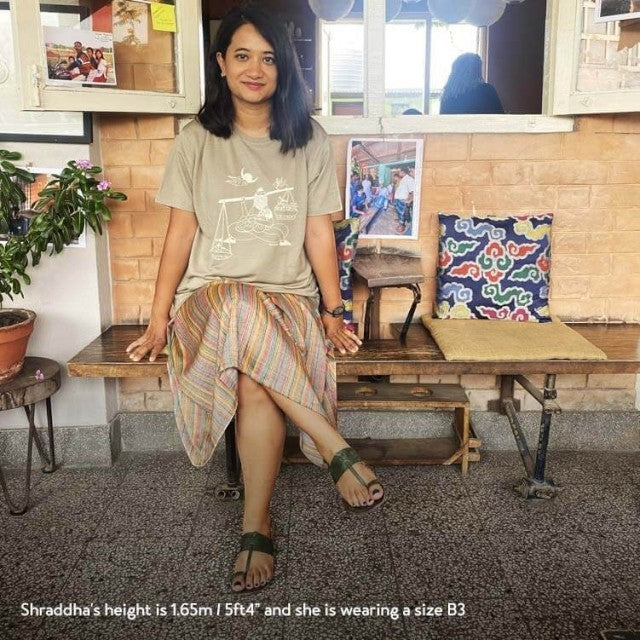 Woman wearing a khaki Baabuk 10th anniversary merino wool t-shirt with a white illustration by Shraddha Shrestha.