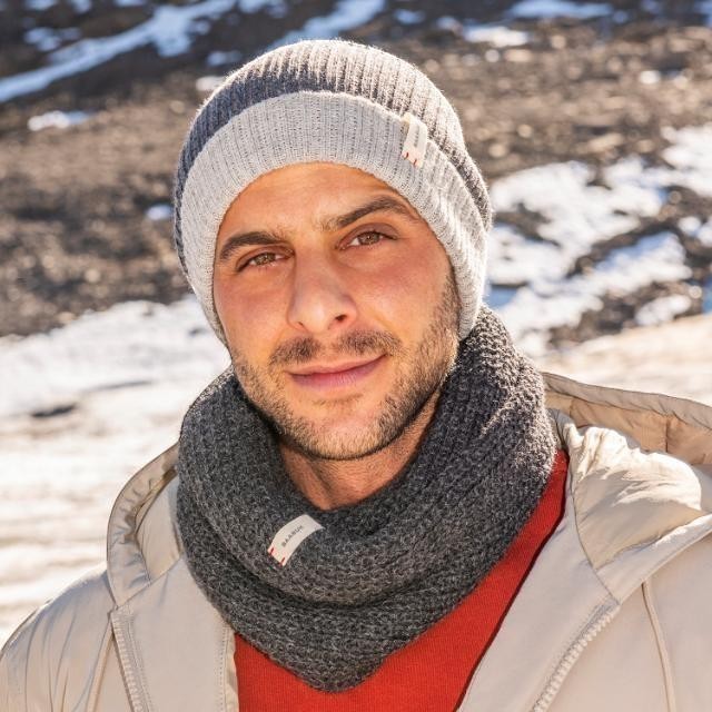 Baabuk reversible dark grey and light grey baby alpaca wool beanie worn by a man in a snowy outdoor setting