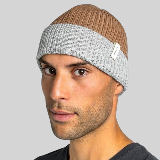Baabuk reversible camel and grey baby alpaca wool beanie worn by a man, featuring a ribbed knit design.