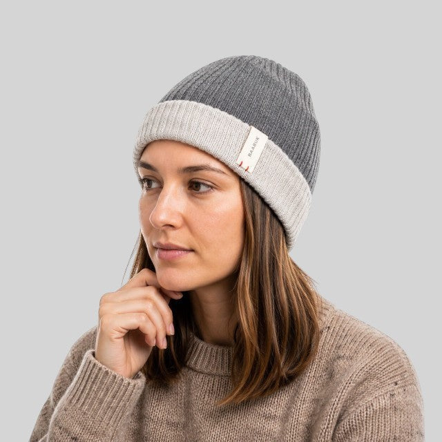 Woman wearing a Baabuk reversible dark grey and light grey baby alpaca wool beanie with a ribbed knit texture.