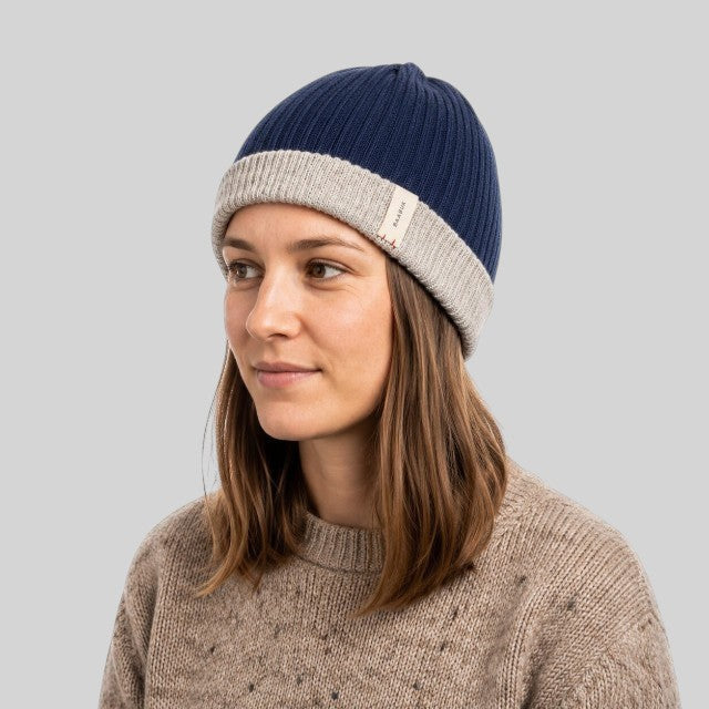 Baabuk reversible marine blue and grey baby alpaca wool beanie worn by a woman